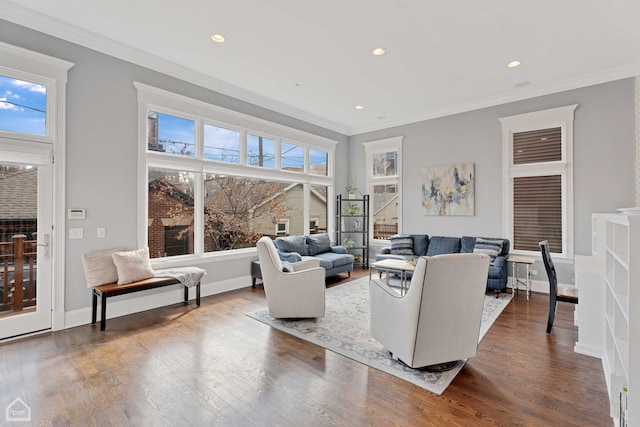 living room with ornamental molding, wood finished floors, and baseboards