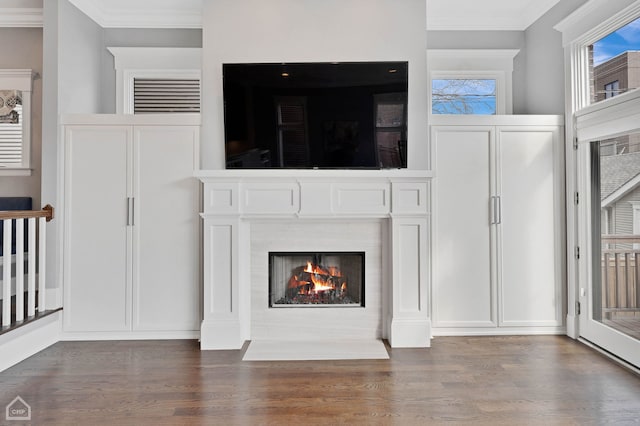 unfurnished living room with ornamental molding, a fireplace with flush hearth, and wood finished floors