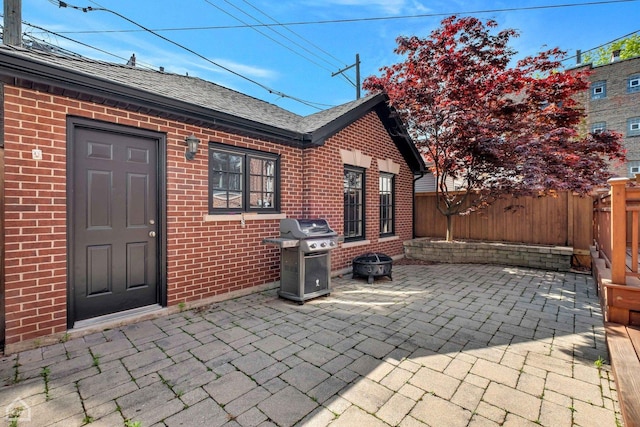 view of patio / terrace with an outdoor fire pit, area for grilling, and fence