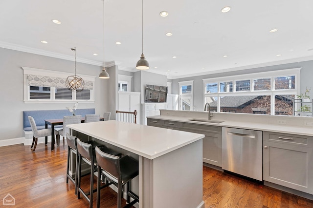 kitchen with a kitchen island, a sink, stainless steel dishwasher, gray cabinets, and dark wood-style floors