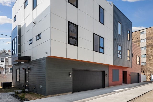 view of property featuring a garage and central AC