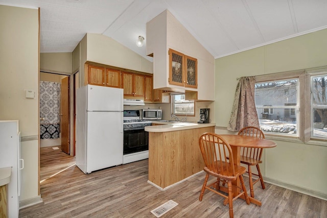 kitchen with under cabinet range hood, a peninsula, white appliances, visible vents, and light countertops