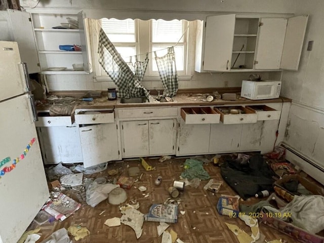 kitchen with open shelves, baseboard heating, white cabinets, a sink, and white appliances