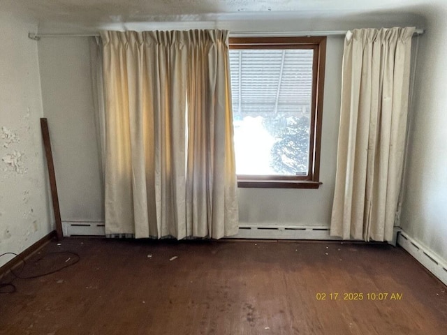 spare room featuring dark wood-style floors and baseboard heating