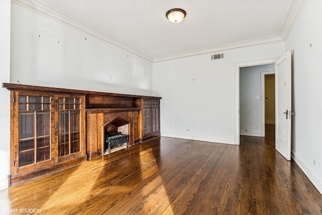 unfurnished living room with crown molding, wood finished floors, visible vents, and baseboards