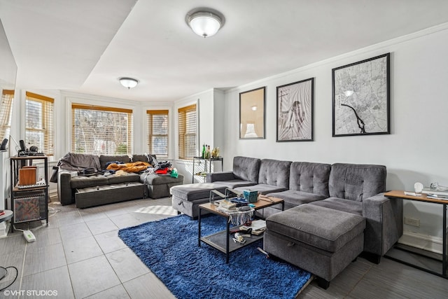 living area with plenty of natural light, light tile patterned floors, and ornamental molding