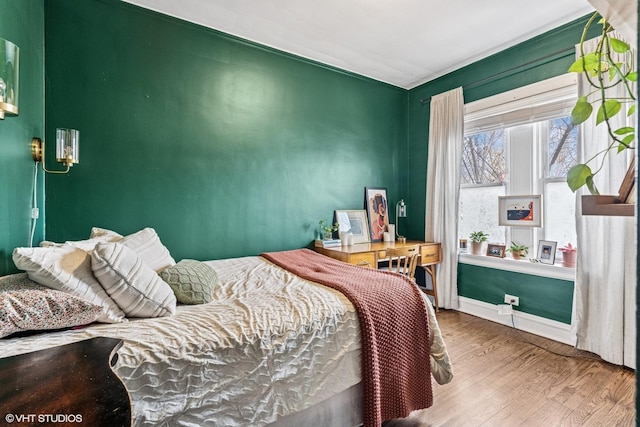 bedroom featuring baseboards and wood finished floors