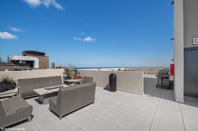 view of patio / terrace featuring an outdoor living space with a fire pit and a water view