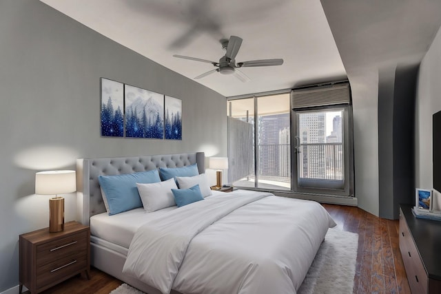 bedroom with floor to ceiling windows, dark wood-style flooring, a ceiling fan, and access to exterior