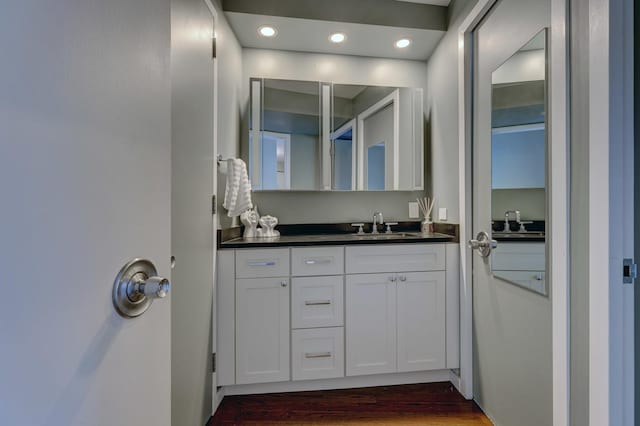 bathroom with recessed lighting, vanity, and wood finished floors