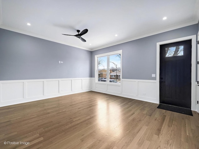 entrance foyer featuring wood finished floors, a ceiling fan, recessed lighting, ornamental molding, and wainscoting