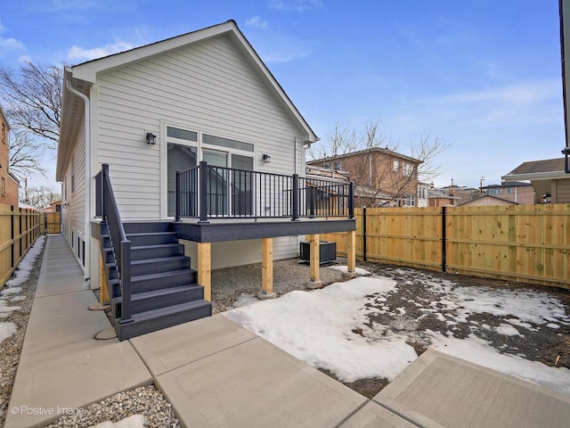 back of house featuring central AC, stairway, and fence private yard