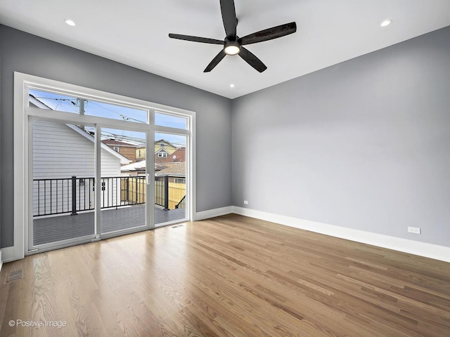 empty room with a ceiling fan, visible vents, light wood-style flooring, and baseboards