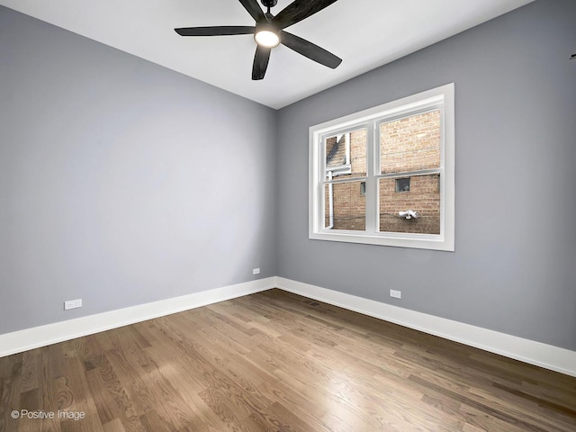 unfurnished room featuring ceiling fan, baseboards, and wood finished floors