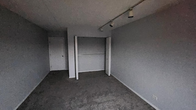 unfurnished bedroom with track lighting and multiple closets