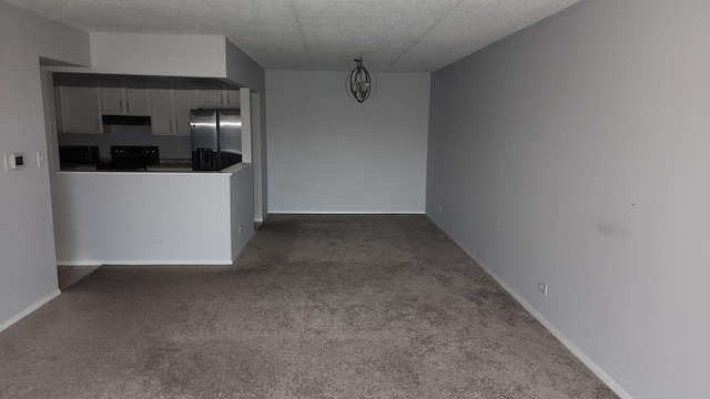 unfurnished living room featuring baseboards, dark carpet, and a textured ceiling