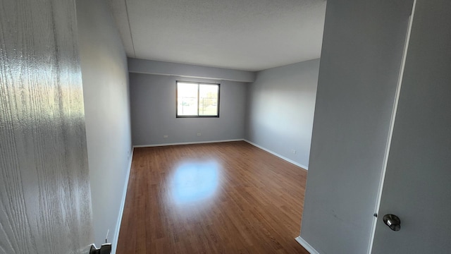 unfurnished room featuring baseboards and wood finished floors