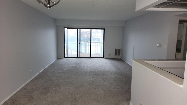 unfurnished living room with visible vents, baseboards, and carpet floors