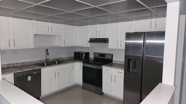 kitchen featuring under cabinet range hood, black appliances, white cabinets, and a sink