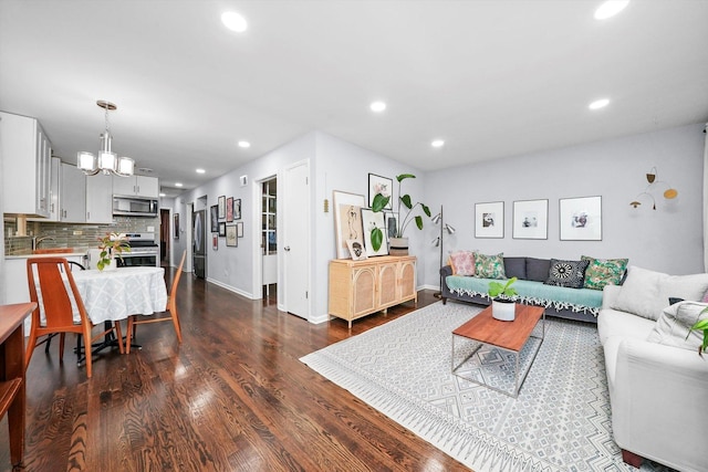 living room with baseboards, a chandelier, dark wood finished floors, and recessed lighting