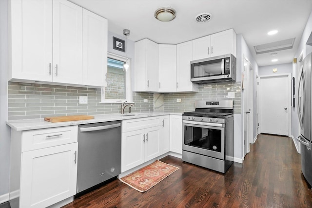 kitchen featuring white cabinets, appliances with stainless steel finishes, and light countertops