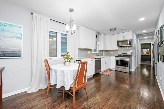 kitchen with stainless steel appliances, light countertops, and white cabinetry