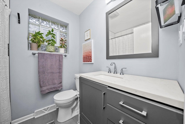 full bath with toilet, vanity, visible vents, and baseboards