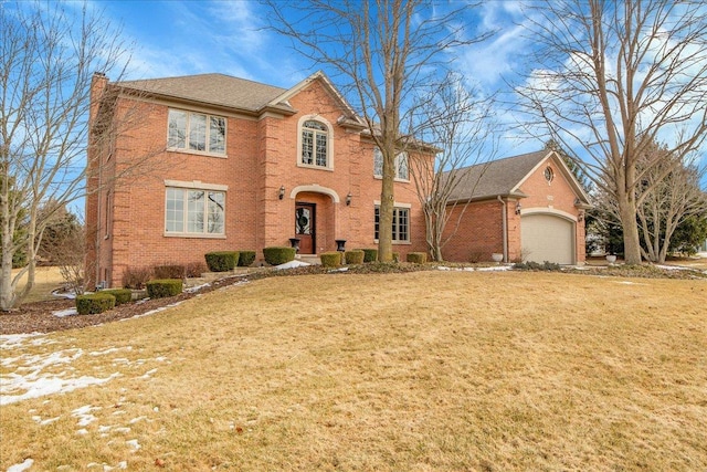 view of front of home featuring a chimney, a front lawn, and brick siding