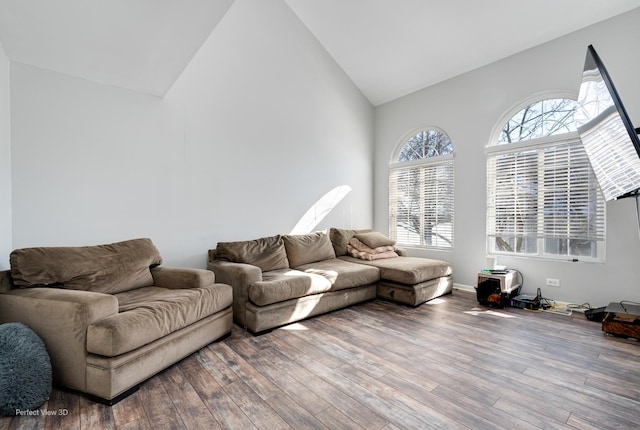 living area with high vaulted ceiling and wood finished floors