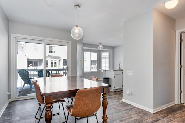 dining area featuring dark wood-type flooring and baseboards