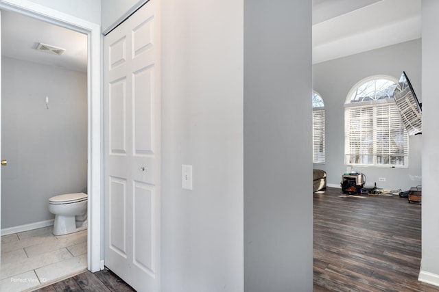 interior space featuring dark wood-style flooring, visible vents, and baseboards