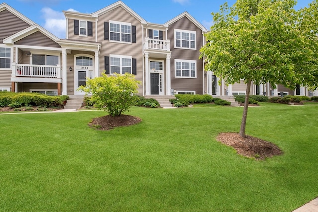 view of front of house featuring a front lawn and a balcony