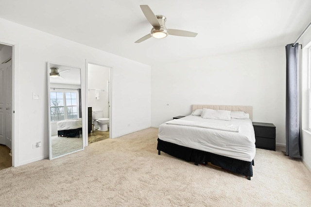 bedroom with carpet floors, connected bathroom, and a ceiling fan