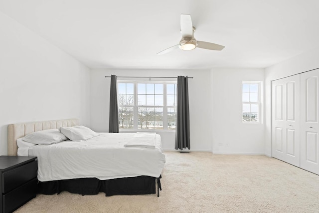 bedroom with carpet, a closet, multiple windows, and ceiling fan