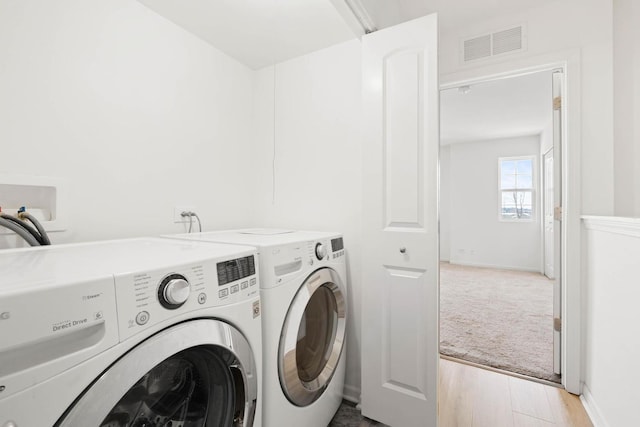 laundry room with laundry area, visible vents, baseboards, light wood-style flooring, and separate washer and dryer