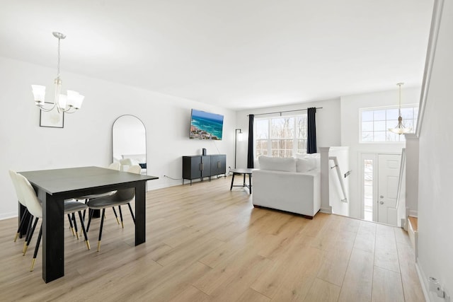 dining room featuring an inviting chandelier, light wood-style flooring, and baseboards