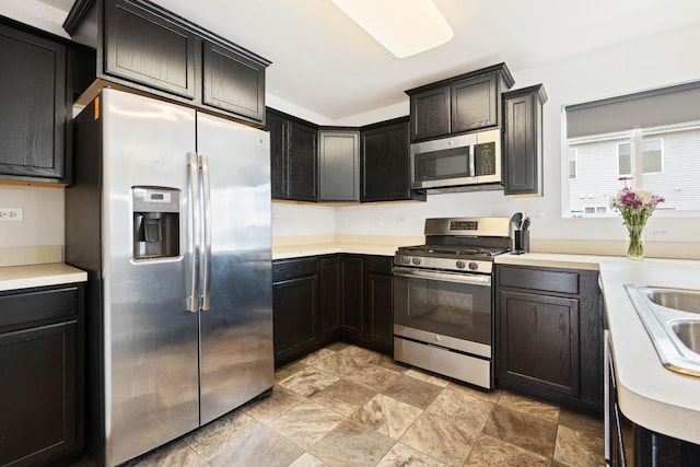 kitchen featuring light countertops, appliances with stainless steel finishes, and a sink