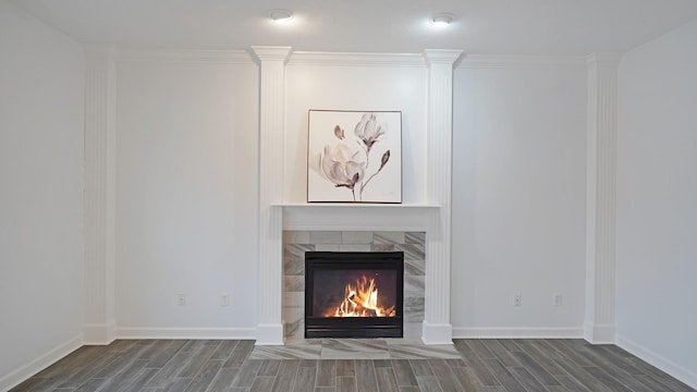 unfurnished living room featuring wood tiled floor, a fireplace, ornamental molding, and baseboards