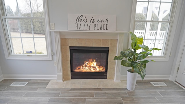 room details featuring baseboards, visible vents, and a tiled fireplace