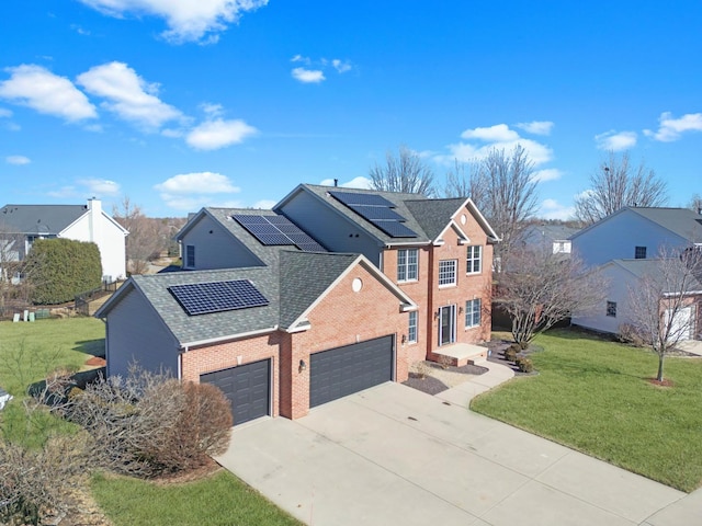 traditional-style home featuring brick siding, concrete driveway, solar panels, an attached garage, and a front yard