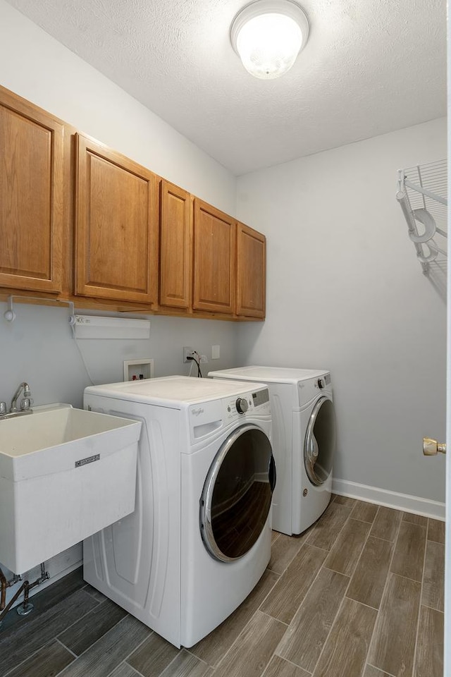 washroom with washer and dryer, cabinet space, and wood tiled floor