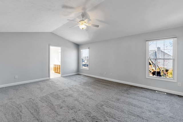 interior space featuring lofted ceiling, ceiling fan, visible vents, and baseboards