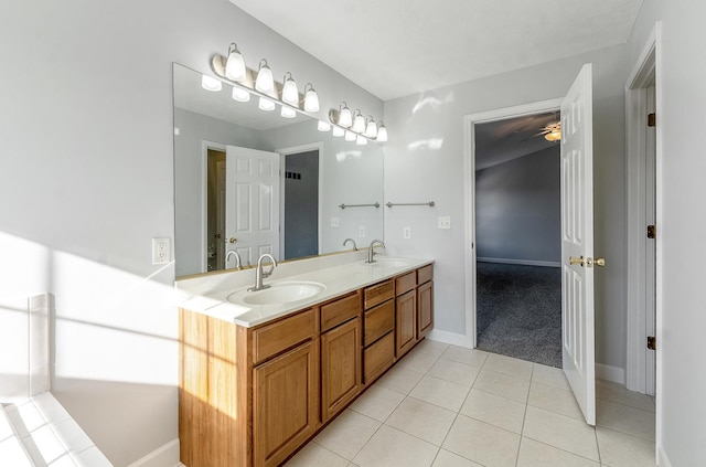 bathroom with double vanity, a sink, baseboards, and tile patterned floors