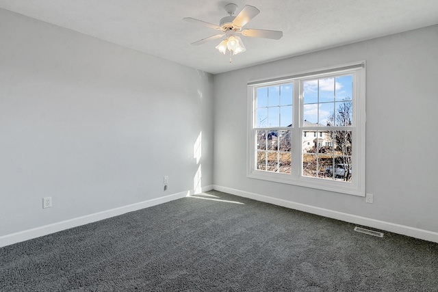 unfurnished room featuring ceiling fan, visible vents, baseboards, and dark carpet