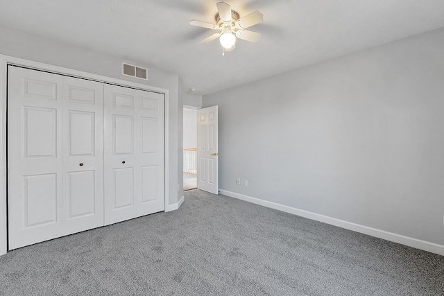 unfurnished bedroom with baseboards, visible vents, a ceiling fan, carpet flooring, and a closet