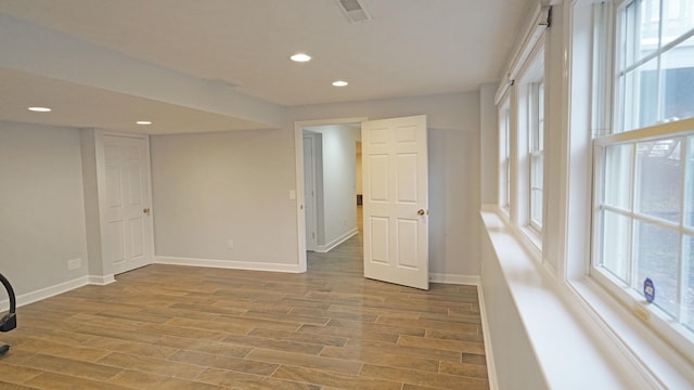 unfurnished room with recessed lighting, visible vents, baseboards, and wood finished floors