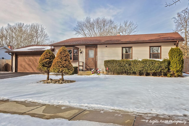 single story home with a garage, a chimney, fence, and driveway