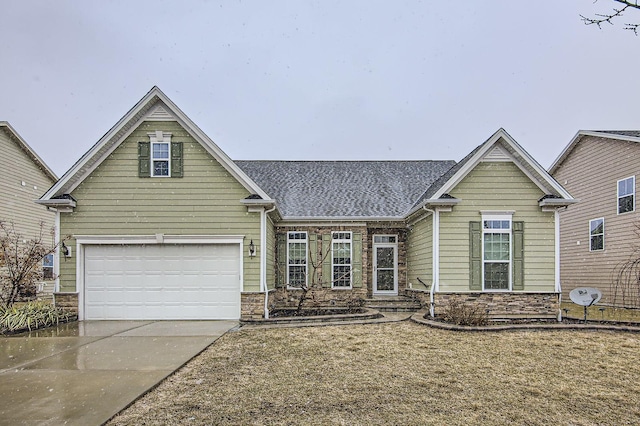 traditional-style house featuring stone siding, driveway, and a garage