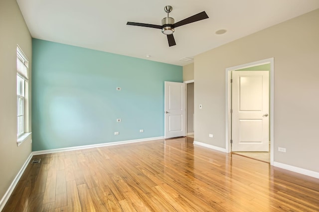 unfurnished bedroom featuring a ceiling fan, light wood-style flooring, visible vents, and baseboards