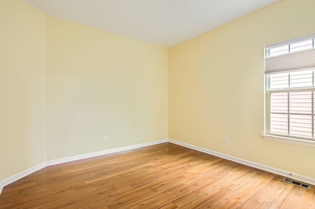 spare room with baseboards, visible vents, and light wood-type flooring